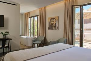 a bedroom with a bed and a tub and a bathroom at Sant Jaume Design Hotel in Palma de Mallorca