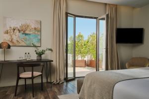 a hotel room with a bed and a desk and a sliding glass door at Sant Jaume Design Hotel in Palma de Mallorca