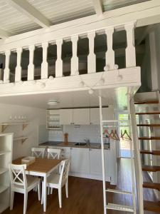 a loft bed in a kitchen with a table and chairs at Calma bungalows in Portorož +6 photos