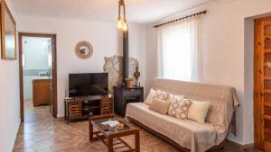 a living room with a couch and a television at Casa Pulirio Antequera - La Higuera by Ruralidays in Antequera