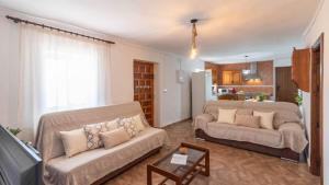 a living room with two couches and a kitchen at Casa Pulirio Antequera - La Higuera by Ruralidays in Antequera