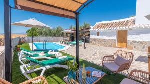 a patio with chairs and a swimming pool at Casa Pulirio Antequera - La Higuera by Ruralidays in Antequera