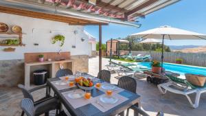 a patio with a table and chairs and a pool at Casa Pulirio Antequera - La Higuera by Ruralidays in Antequera