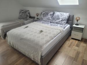 a bedroom with a bed and a night stand with two lamps at Czarna Perła in Chłopy