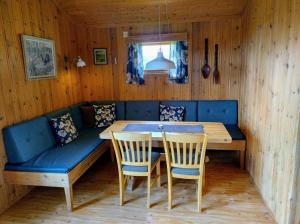 a dining room with a blue couch and a table at Hogstul Hytter - Apartment North in Tuddal