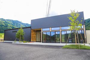 a black building with trees in front of it at Hotel 4CROWNS-ブラックプラン in Katsuyama
