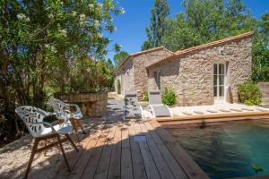 une maison avec une piscine et des chaises sur une terrasse en bois dans l'établissement Gîte nature avec piscine privée, à Montagnac
