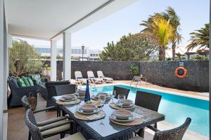 a patio with a table and chairs next to a pool at Villa Mamma Mia 1 in Playa Blanca