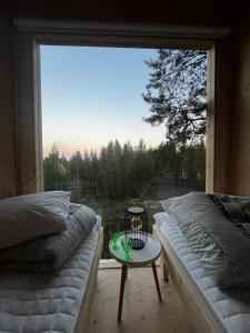 a living room with a couch and a table in front of a window at KoloCabins -Huuhanranta 6 in Ruokolahti