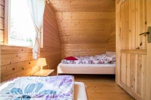 a bedroom with a bed in a wooden cabin at Baltic Holiday in Dębki
