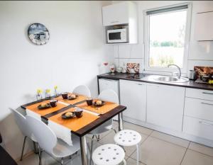 a kitchen with a wooden table and white cabinets at Baltic Holiday in Dębki