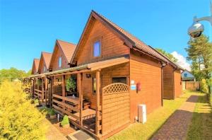 a large wooden house with a large deck at Baltic Holiday in Dębki