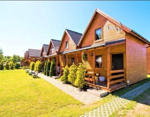 a large wooden house with a green yard at Baltic Holiday in Dębki +6 photos