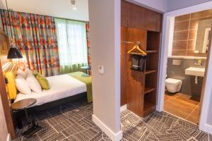 a hotel room with a bed and a bathroom at ibis Styles Leeds City Centre Arena in Leeds +37 photos