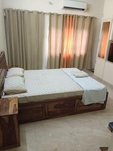 a large bed in a room with curtains at The Olive Greens in Pāonta Sāhib