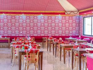 a dining room with tables and chairs and red walls at Golde bubble camp in Wadi Rum +45 photos