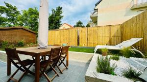 eine Terrasse mit Tisch und Stühlen und einem Zaun in der Unterkunft Maison de vacances à 900m de la plage in Stella-Plage