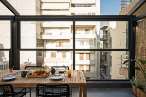 a wooden table with a bowl of fruit on a balcony at L Horizon Luxury Living with Sea View by 8essentially in Heraklio