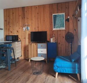 a living room with a desk and a blue chair at Cocooning et plages in Capbreton