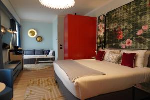 a bedroom with a large bed and a red cabinet at Hotel Indigo Florence by IHG in Florence