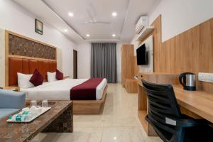 a hotel room with a bed and a desk at Gateway Inn in Bangalore