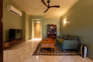 ein Wohnzimmer mit Sofa und Fernseher in der Unterkunft Lily Lakes - Resort Style Living in Cairns