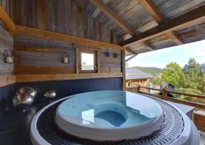 ein Badezimmer mit blauer Badewanne auf einer Terrasse in der Unterkunft Chalets Collection Greniers D'Alpages - Les Chalets Secrets in Bolquere