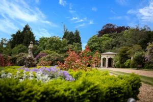 a garden with flowers and a gazebo at Shendish Manor Hotel & Golf Course in Hemel Hempstead