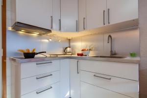 Una cocina con gabinetes blancos y un fregadero. en Résidence Le Prarion 24A ski in- ski out - Happy Rentals, en Les Houches