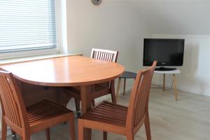ein Esszimmer mit Tisch und Stühlen und einem Fernseher in der Unterkunft Haus Barbara - Schwimmbad und Sauna im Haus - Whg 3 in Grömitz