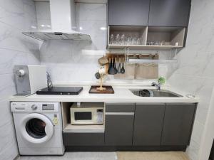 une cuisine avec une machine à laver et un évier dans l'établissement stc 1, à Séoul 8 autres photos