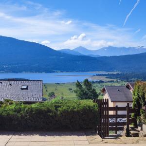 a house with a fence and a view of a lake at Appartement les Angles in Les Angles +6 photos