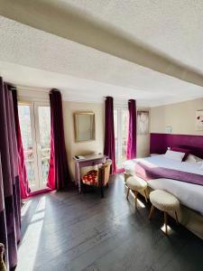 a bedroom with two beds and pink curtains at Le Grand Hotel in Forcalquier