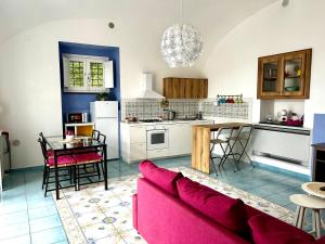 a living room and kitchen with a red couch at Antica Residenza la Vela in Meta