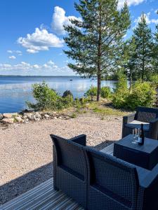 un patio con 2 sedie e un tavolo accanto all'acqua di Halsuan Helmi a Halsua