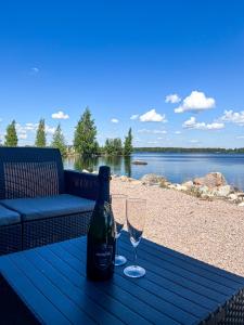 una bottiglia di vino e due bicchieri su un tavolo da picnic di Halsuan Helmi a Halsua Altre 3 foto