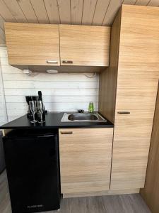 una piccola cucina con lavandino e armadi in legno di Halsuan Helmi a Halsua