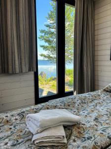 un letto con due cuscini sopra di una finestra di Halsuan Helmi a Halsua