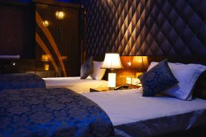 a hotel room with two beds and a lamp at Hote Meghnath Palace in Dhupguri +27 photos