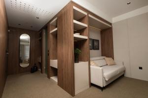 a living room with a couch and a mirror at Infinity Hotel & More in Budva