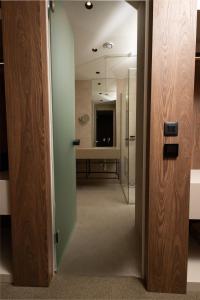 a hallway with a bathroom with a shower and a mirror at Infinity Hotel & More in Budva