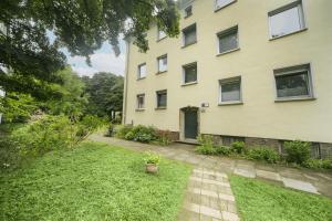 un edificio de apartamentos con un patio delante en FeWo Phönixhütte am Baldeneysee in Kupferdreh, en Essen