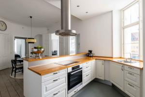 a kitchen with white cabinets and a wooden counter top at Chic Apartment in Vibrant Area by Copenhagen Canals in Copenhagen