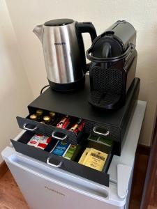 a coffee maker and a pot on top of a refrigerator at The Grapevine by MANVI in Montepulciano