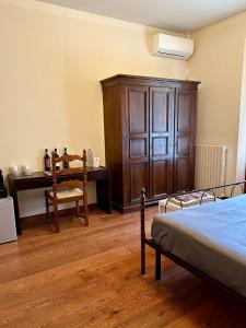 um quarto com uma secretária, uma cama e um armário de madeira em The Grapevine by MANVI em Montepulciano mais 37 fotografias