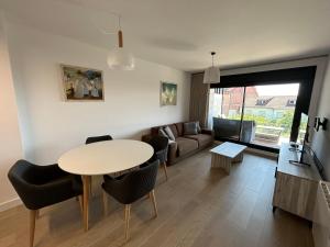 una sala de estar con una mesa y un sofá en Apartamento Playa Canelas II, en Portonovo