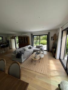 a living room with a couch and a table at Villa piscine plein sud proche Uzes in Arpaillargues-et-Aureillac