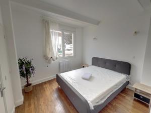 a bedroom with a bed and a window at Maison Cosy à Saint-Dizier in Saint-Dizier