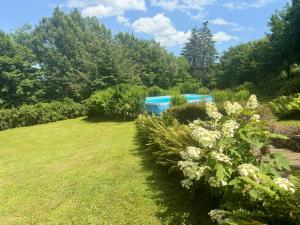 a garden with a pool in the background at Chalet Bosco Magico Roccolo in CastellʼArquato