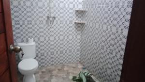 a bathroom with a toilet and a tiled wall at House market in Sidemen +87 photos